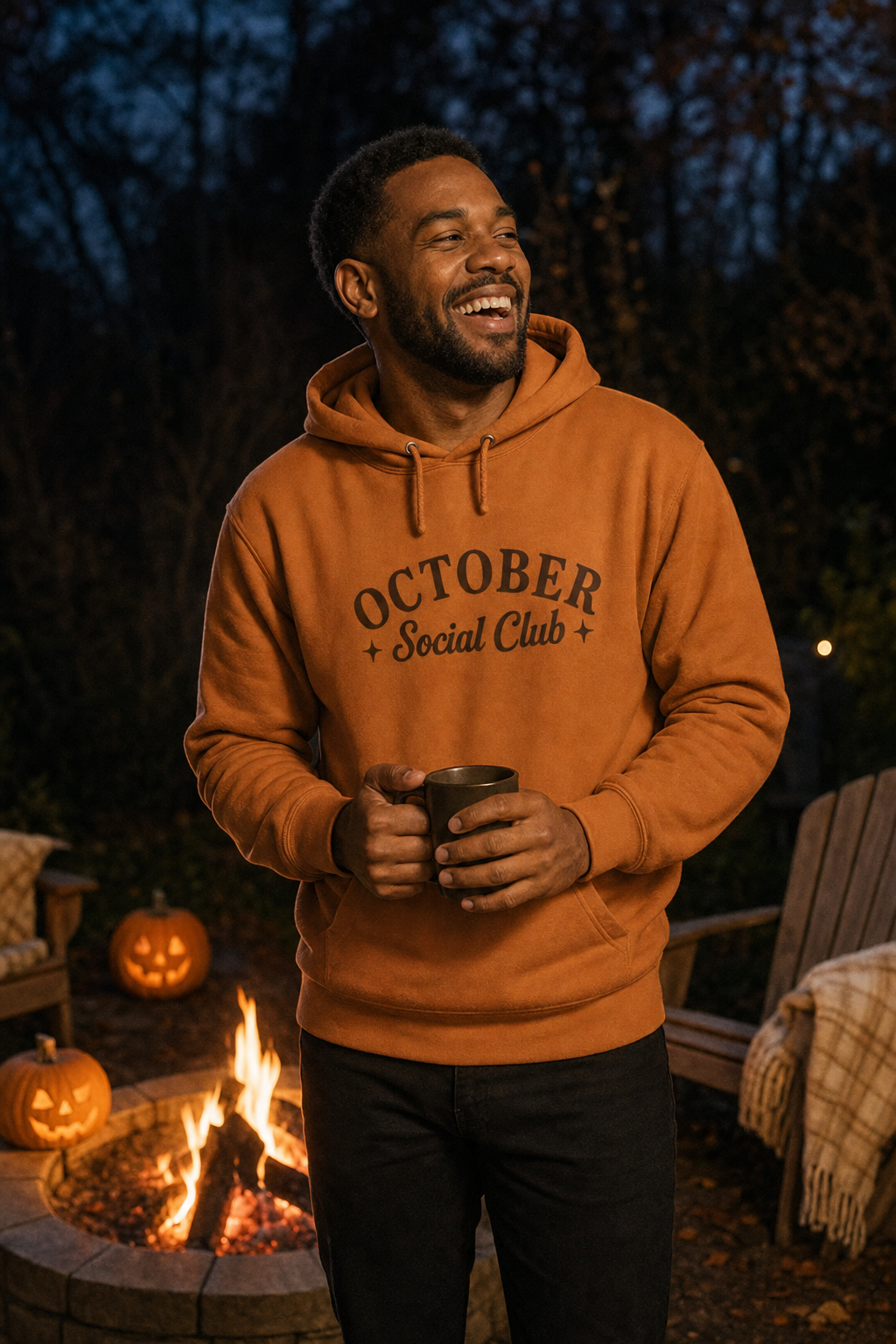 Man beside a garden fire pit wearing the adobe October Social Club hoodie