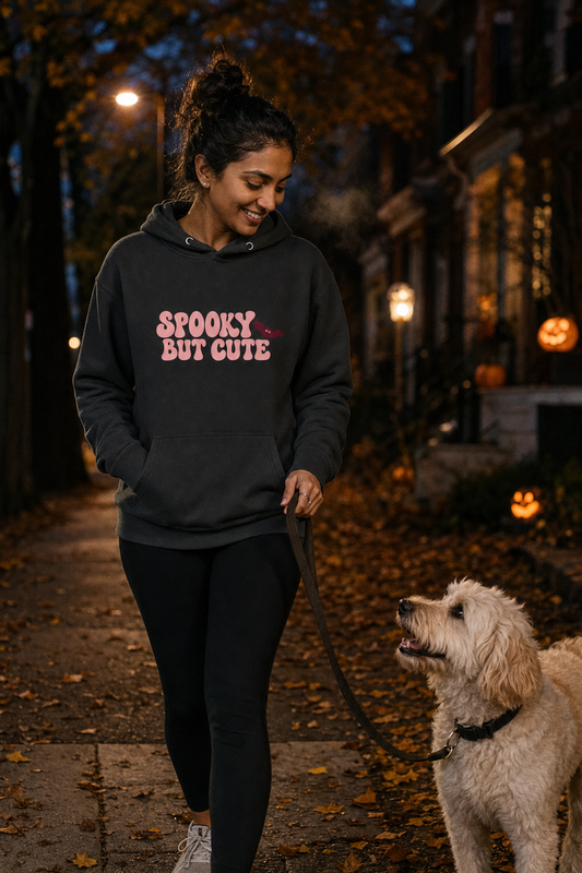 Woman walking her dog at night wearing the vintage black Spooky But Cute hoodie